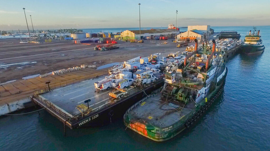 Foss Maritime cargo ship docked at port with containers and equipment.